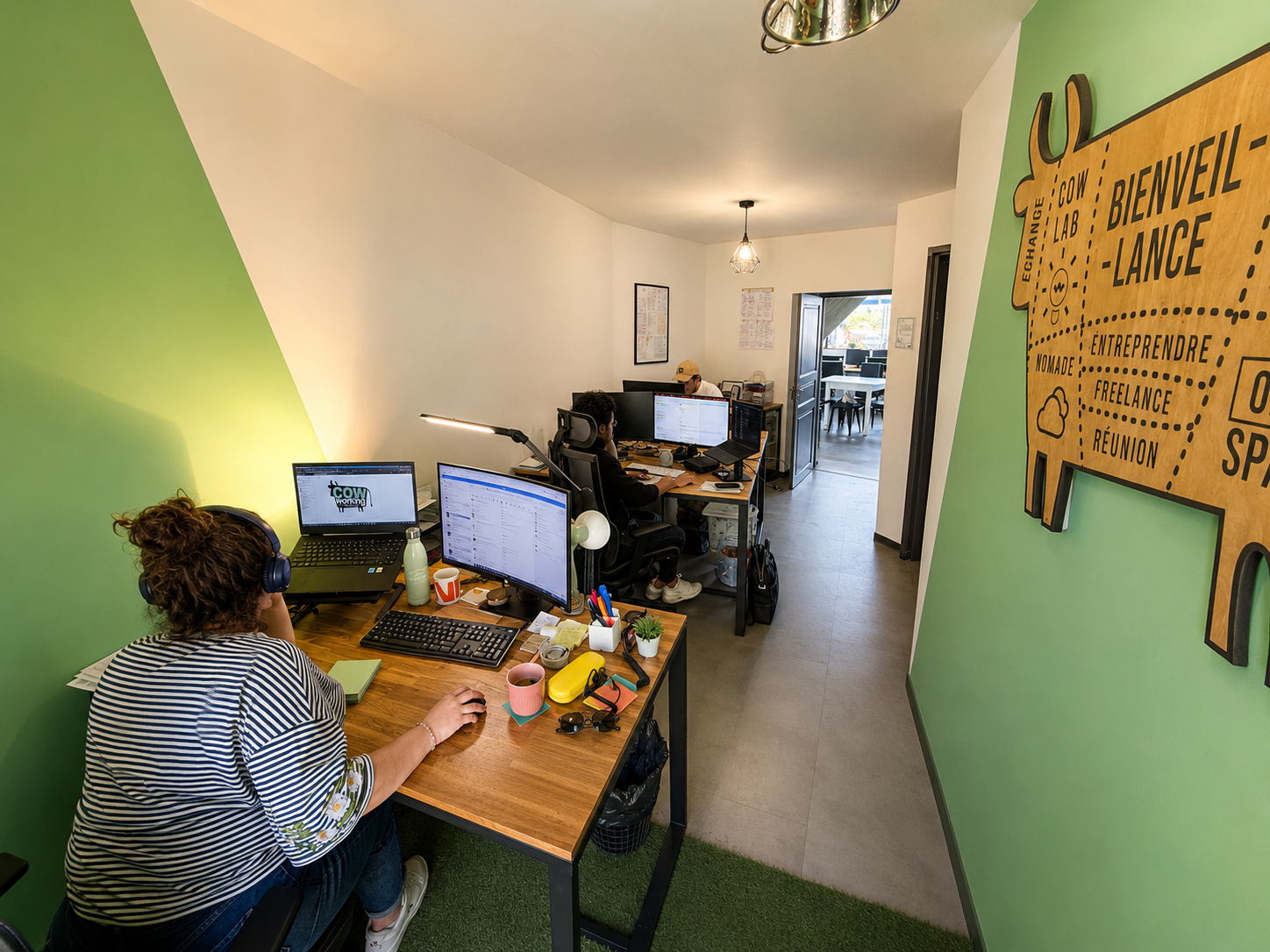 Espace de coworking chaleureux avec bureaux, lumière douce et panneau en bois